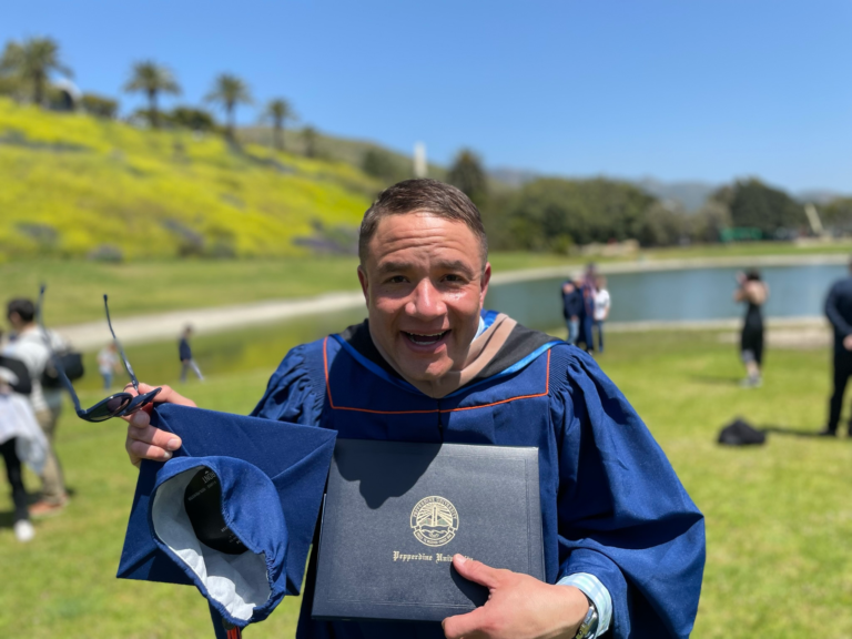 Ian celebrating graduation outdoors